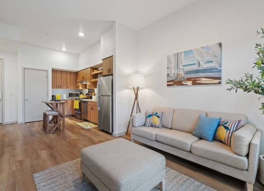 a living room with a couch and a chair and a kitchen
