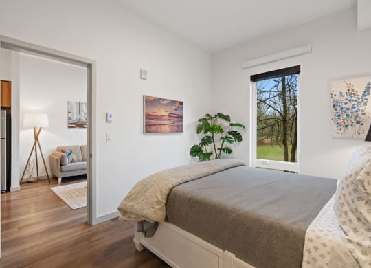 a bedroom with a bed and a door to a living room