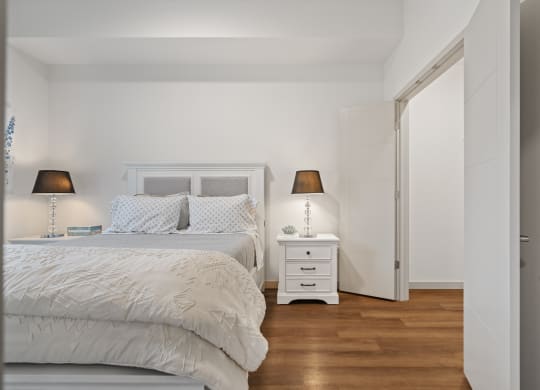 a bedroom with a bed and a nightstand with two lamps