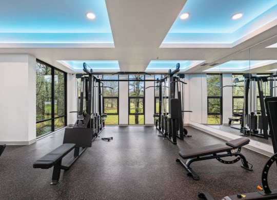 a gym with exercise equipment and windows in a building with glass doors