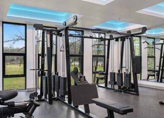 a gym with exercise equipment and windows in a building