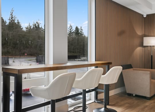 a room with a table and chairs in front of a large window