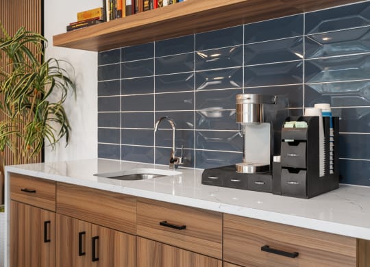 a kitchen counter with a coffee maker and a sink