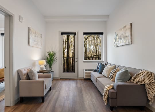 a living room with a couch and two chairs and a door