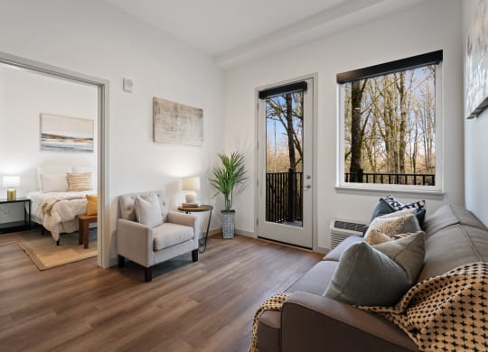 a living room with a couch and chairs and a door to a bedroom