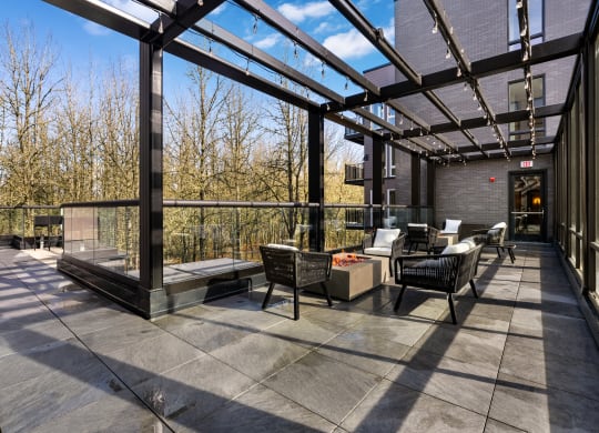 a covered patio with chairs and tables and a fireplace