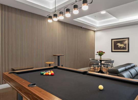 a game room with a pool table and chairs