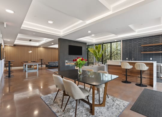a dining room with a black table and chairs and a living room