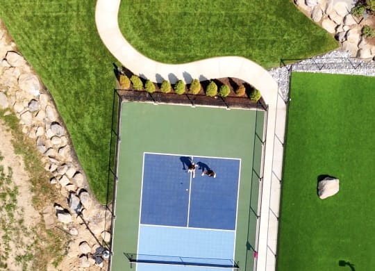 an aerial view of a tennis court on a green court