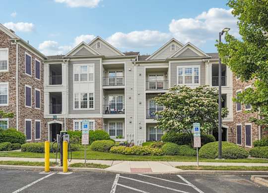 Apartment building with a parking lot in front.