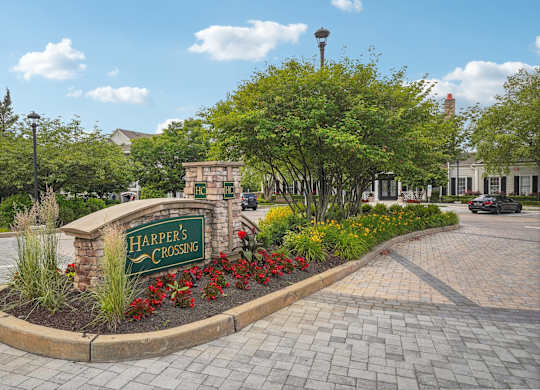 A sign that says Harper's Crossing is in front of a building.