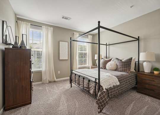 A bedroom with a four poster bed and a nightstand.