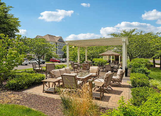 A patio with a table and chairs under a pergola.