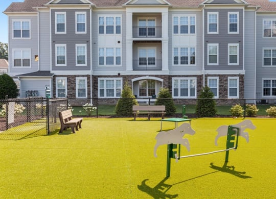 a playground with two horses on it in front of an apartment building  at Harper's Crossing, Langhorne