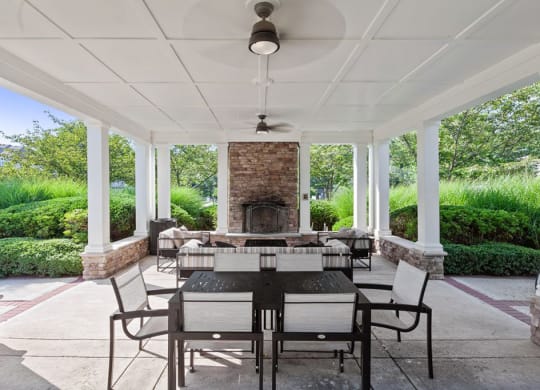a covered patio with a fireplace and a dining table and chairs  at Harper's Crossing, Langhorne, PA, 19047