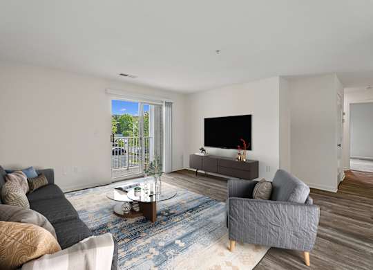 A living room with a grey couch, a coffee table, and a flat screen TV.