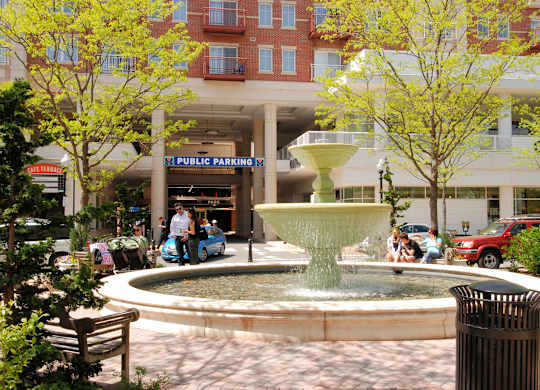 A fountain in the middle of a plaza with a sign that says
