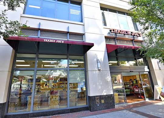 A storefront of Trader Joe's with a red awning and glass doors.