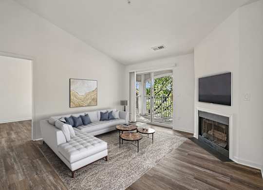 A living room with a white couch and a fireplace.