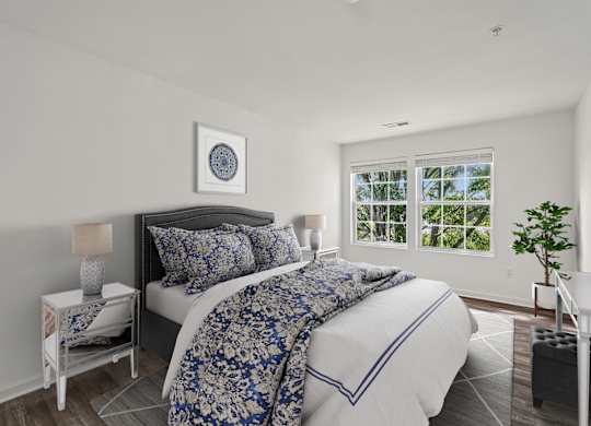 A bedroom with a large bed and a window overlooking trees.