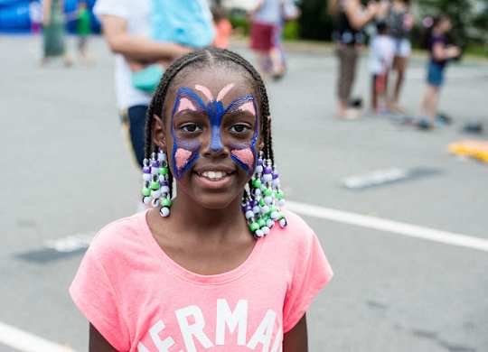 A girl with a butterfly painted on her face.