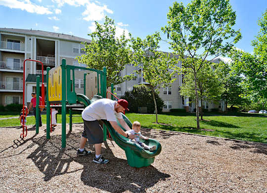 A man and a child playing on a playground.