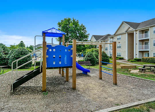 A playground with a blue slide and a wooden structure.