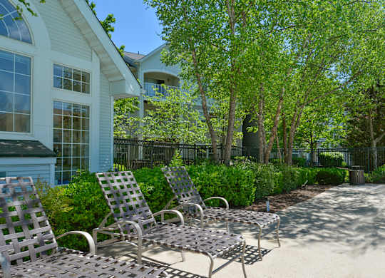 A patio with chairs and a table in front of a house.