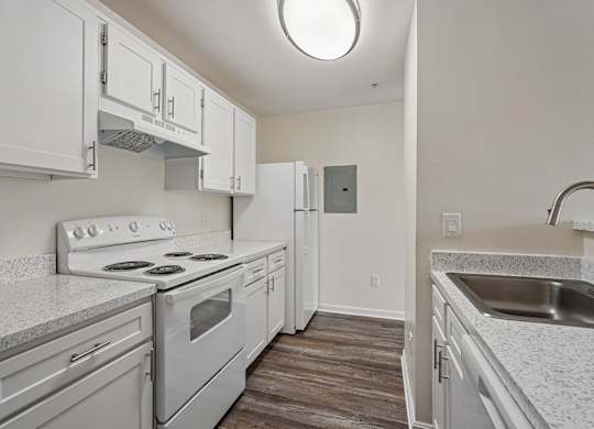 A kitchen with white cabinets and a stove top oven.