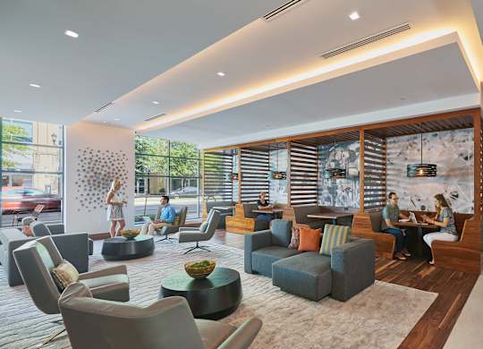 A modern living room with people sitting and chatting.