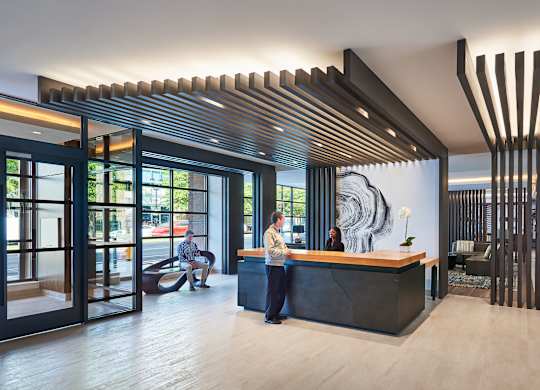 A reception area with a woman standing behind the desk.
