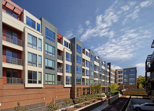 A row of modern apartment buildings with balconies and windows.