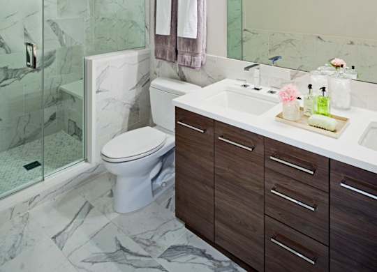A bathroom with a marble floor and a white toilet.
