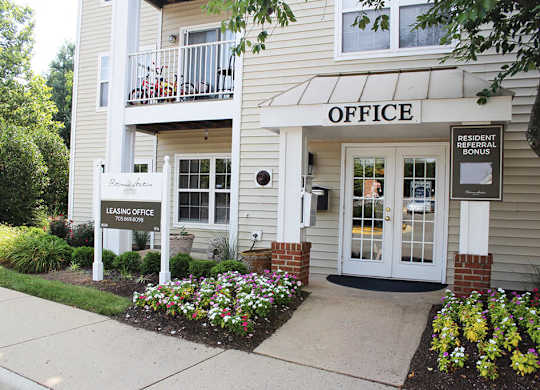 A building with a leasing office sign in front of it.