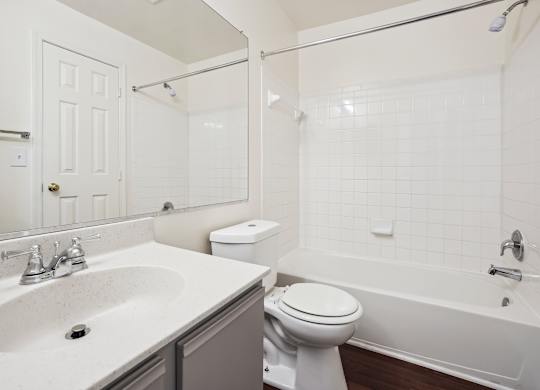 A white bathroom with a toilet, sink, and bathtub.
