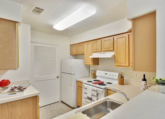 A kitchen with white appliances and wooden cabinets.