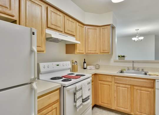 A kitchen with wooden cabinets and white appliances.