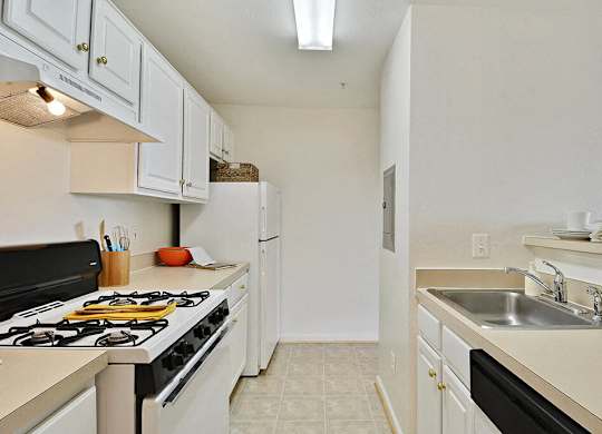 A kitchen with a black stove top oven and white cabinets.