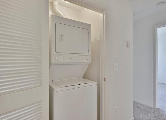 A white washing machine is built into a wall.