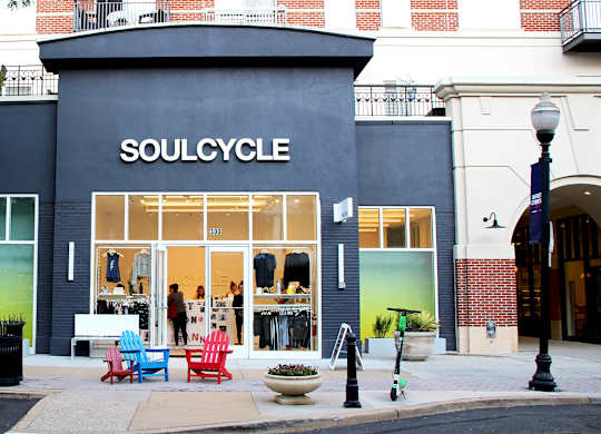 A car is parked in front of a SoulCycle store.