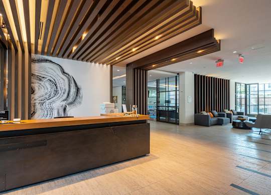 A reception area with a wooden ceiling and a large abstract painting on the wall.