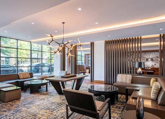 A modern living room with a large window and a chandelier.