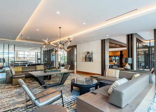 A modern living room with a large grey sofa and a wooden coffee table.