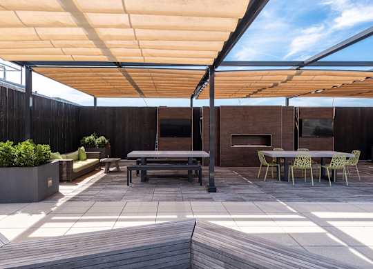 A patio with a table and chairs under a roof.