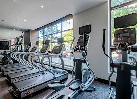 A gym with treadmills and elliptical machines.