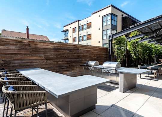 A modern outdoor dining area with a long table and chairs.