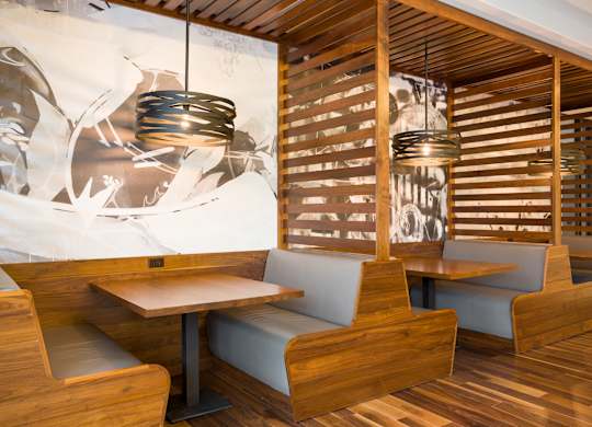A restaurant with wooden chairs and tables.