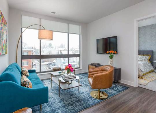 A living room with a blue couch, a coffee table, and a television.