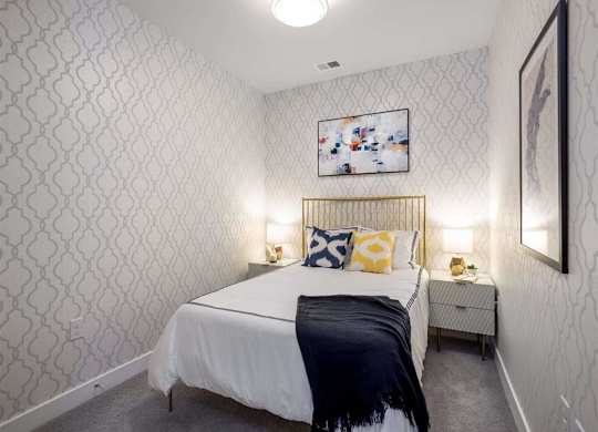 A bedroom with a white bed and a patterned wallpaper.