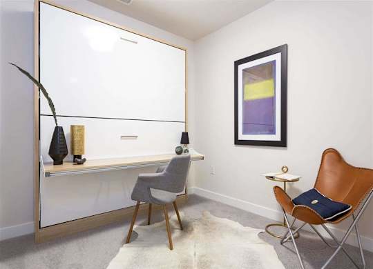 A room with a chair, a table, and a shelf with vases.